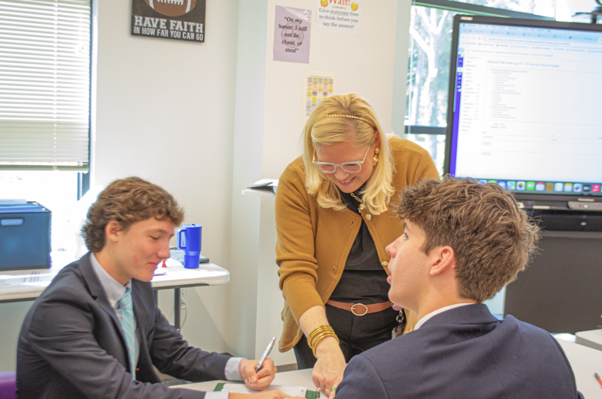 Mrs. Alexis Reyes, Upper School dean of academics, aids freshmen Reed Altsuler and Liam Thomas with a class assignment. Although she is an administrator, Mrs. Reyes also teaches a world history honors class. “This was our practice quiz from reading notes on Tang and Song China,” Mrs. Reyes said.   